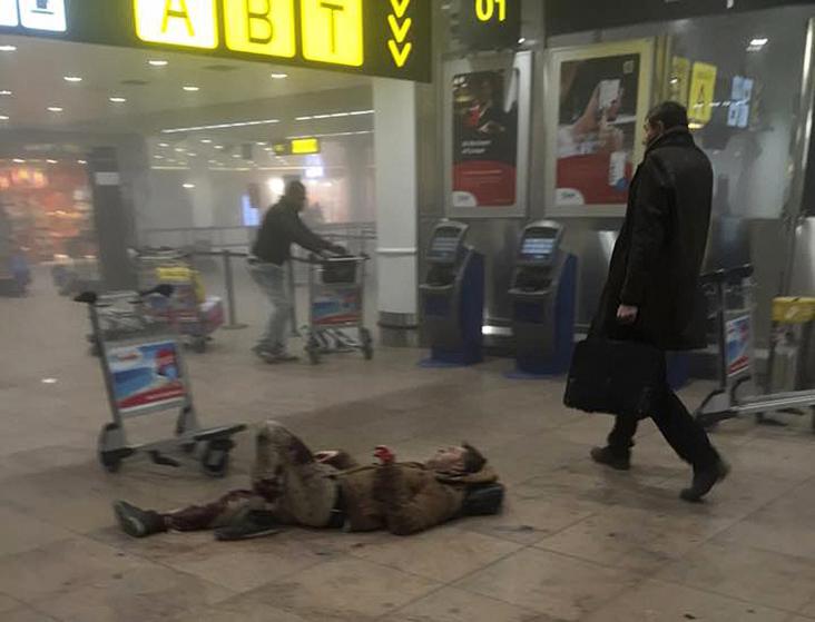 An injured man is seen at the scene of explosions at Zaventem airport near Brussels
